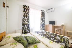 una camera con due letti e una finestra con tende di Pensiunea Versant a Băile Herculane Altre 42 foto