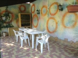 a table and chairs in front of a wall with graffiti at Agria Retur Vendégház in Eger