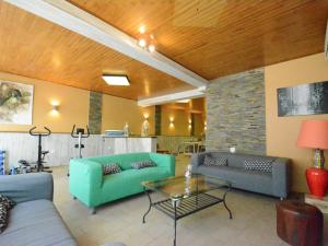 sala de estar con sofás azules y mesa de cristal en Holiday Home with bubble bath opened from 1 2 May to end of September en Florenville