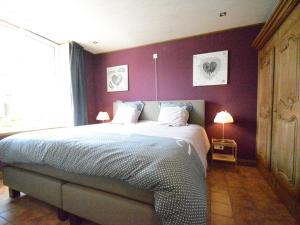 een slaapkamer met een groot bed met paarse muren bij Holiday Home with bubble bath opened from 1 2 May to end of September in Florenville