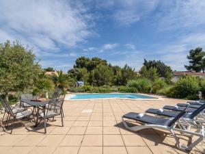 Pouzols-MinervoisにあるSpacious villa in Pouzols Minervois with poolのパティオ(椅子、テーブル、プール付)