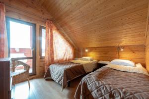 een slaapkamer met 2 bedden in een houten hut bij База отдыха "Вохотка" in Ol'khovka