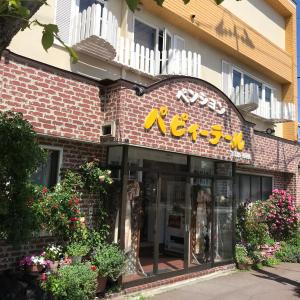 a restaurant with a sign on the front of a building at Pension Puppy Tail in Hakodate