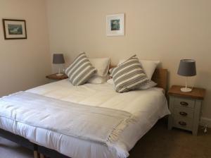 een slaapkamer met een bed met 2 kussens erop bij Brandoch Lodge in Logierait