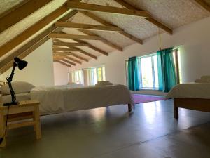 a bedroom with two beds and wooden ceilings and windows at Gomkers Guest House in Gomkʼ