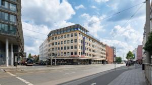 a large building on a city street with a road at a&o Nürnberg Hauptbahnhof in Nürnberg