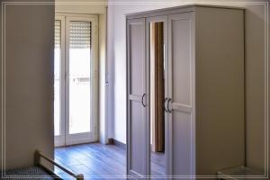 una stanza con specchio e porta per un corridoio di B&B Sicily a Porto Empedocle