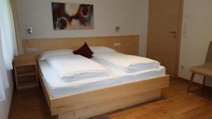 un letto in legno con due cuscini sopra di Residence Klementhof a Naz-Sciaves