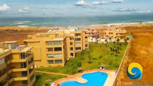 an aerial view of a resort with a swimming pool and the ocean at Cozy & Luxurious apartment with seaview in Bouznika