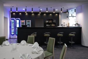 ein Esszimmer mit Tisch und Stühlen und einer Bar in der Unterkunft Hotel Sport in Bełchatów + 29 Fotos