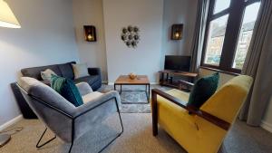 sala de estar con 2 sillas y sofá en StayZo 2BR House Accommodation in Peterborough, en Peterborough