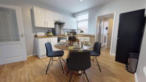 cocina con mesa y sillas en una habitación en StayZo 2BR House Accommodation in Peterborough, en Peterborough