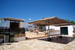 a patio with a table and an umbrella at Cortijo del Coco in Fuente de Piedra