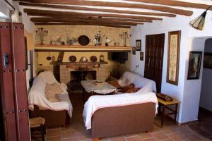 a living room with two beds and a fireplace at Cortijo del Coco in Fuente de Piedra