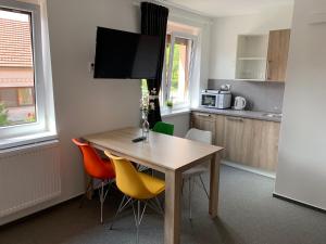 a kitchen with a wooden table and chairs at Mikulov Inn - Apartments Slunce in Mikulov