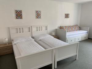 two white beds in a room withermottermottermott at Mikulov Inn - Apartments Slunce in Mikulov