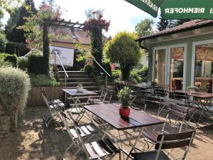 eine Terrasse mit Tischen und Stühlen im Hof in der Unterkunft Gasthof Lindenwirt in Denkendorf