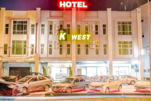 a hotel with cars parked in front of it at K West Hotel in Sitiawan