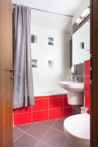 a bathroom with a toilet, sink, and tub at Hotel Bratislava in Bratislava