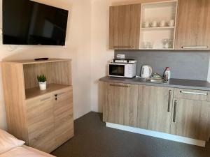 a small kitchen with a sink and a microwave at Mikulov Inn - Apartments Slunce in Mikulov