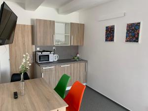 a small kitchen with a table and a microwave at Mikulov Inn - Apartments Slunce in Mikulov