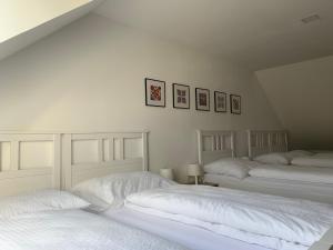 two beds in a bedroom with white walls at Mikulov Inn - Apartments Slunce in Mikulov