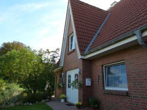 ein rotes Backsteinhaus mit einer weißen Tür in der Unterkunft Gästehaus Amrumer 36 in Büsum