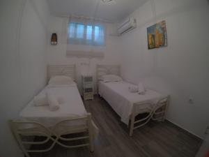una habitación con dos camas y una ventana en Fantastic Cycladic Maisonette Olga in Naoussa, en Naousa