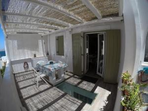 un patio al aire libre con mesa y piscina en Fantastic Cycladic Maisonette Olga in Naoussa, en Naousa