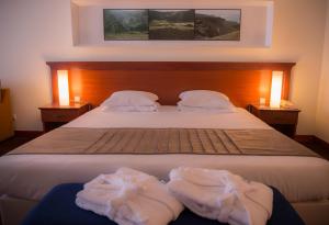 a bedroom with a bed with two towels on it at Azoris Faial Garden – Resort Hotel in Horta