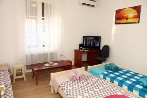a small room with two beds and a table at Apartma Grof in Koper