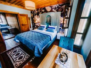 a bedroom with a bed with a blue comforter at Misgibi Hotel in Bursa