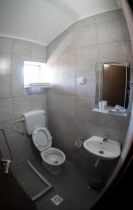 a small bathroom with a toilet and a sink at DIONIS Rooms & Apartments in Prilep