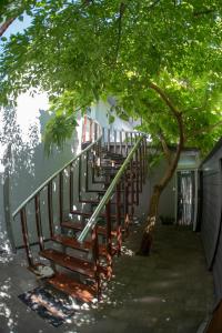 a wooden staircase next to a building with a tree at DIONIS Rooms & Apartments in Prilep