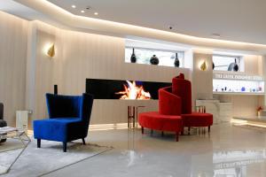 a living room with two chairs and a fireplace at St George Lycabettus Lifestyle Hotel in Athens