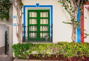 a blue and white window with a plant in it at Apartamentos Puerto de Mogán THe Home Collection in Puerto de Mogán