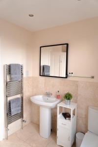 uma casa de banho com um lavatório e um espelho na parede em A Stay On The Brae em Edinburgo