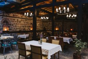 a restaurant with tables and chairs and a brick wall at Misgibi Hotel in Bursa