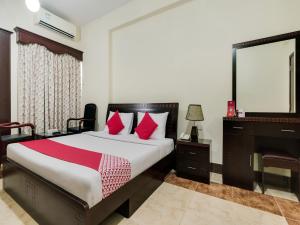 a bedroom with a bed with red pillows and a desk at Al Rayan Hotel in Ajman 