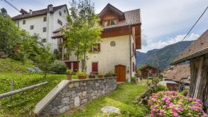 une maison dans un village avec un mur en pierre dans l'établissement Albergo Diffuso Ravascletto, à Ravascletto