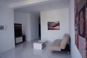 a living room with a couch and a television at AL Guesthouse in Praia