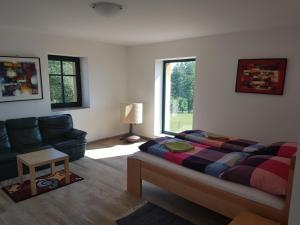 um quarto com uma cama, um sofá e uma janela em Penzion/Motorest Na Písku em Čáslav