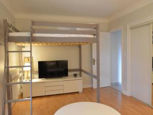 ein Wohnzimmer mit einem Etagenbett und einem TV in der Unterkunft Appartement de vacances avec jardin à Tarnos in Tarnos