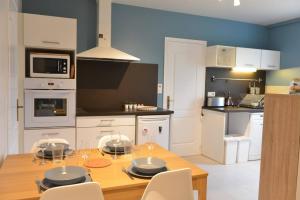 a kitchen with a wooden table with chairs and a dining room at Appartement de vacances avec jardin à Tarnos in Tarnos