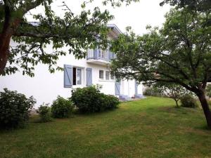 a white house with a balcony and a yard at Appartement de vacances avec jardin à Tarnos in Tarnos