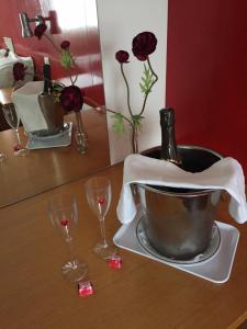 einen Tisch mit Weingläsern und einen Eimer mit einer Flasche in der Unterkunft Hotel Eco Salvador in Geres