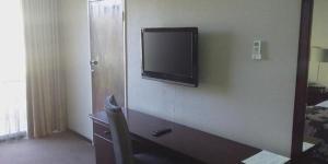 einen Flachbild-TV an der Wand in einem Hotelzimmer in der Unterkunft Welkom Inn in Welkom