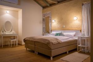 a bedroom with a large bed and a mirror at Vila na Kamenu in Dobrinj