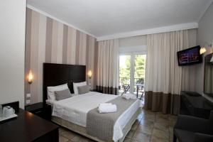 a hotel room with a bed and a balcony at Nostos Hotel in Afitos