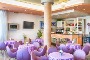 ベッラーリア・イジェア・マリーナにあるHotel Meritimeの紫のテーブルと紫の椅子が備わる部屋